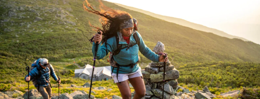 A woman and man hiking at sunset.